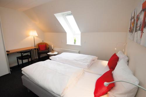 格罗斯滕Benniksgaard Anneks的一间卧室设有两张白色的床和天窗