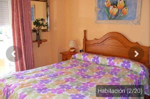 托里代巴拉Casa _pareada con piscina y jardin privado的一间卧室配有一张带五颜六色棉被的床