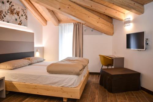 加尔达湖滨Theresia的一间卧室配有一张床、一张书桌和一台电视