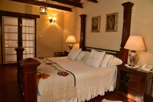 卡法亚特比库尼亚葡萄酒别墅精品酒店的一间卧室配有一张床,桌子上配有一部电话