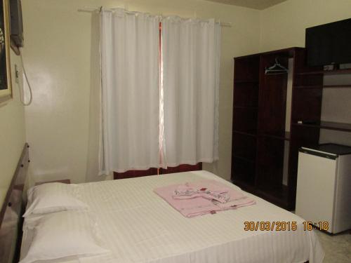 CambuciPousada Beija Flor的卧室配有白色的床和窗户