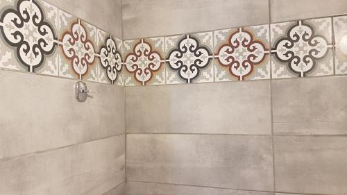 圣加利尼Erofili Rooms的一间带淋浴的浴室和瓷砖墙
