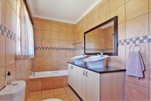 WallmannstalMonateng Safari Lodge的一间带水槽、卫生间和镜子的浴室