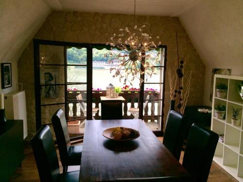 坎普-博尔恩霍芬Villa Christina的一间带桌椅和吊灯的用餐室