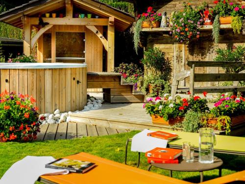夏蒙尼-勃朗峰庄园酒店的花园设有木甲板和热水浴池