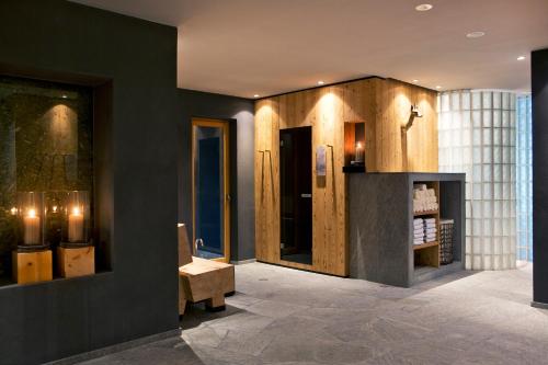 阿尔卑斯休斯山ICARO Hotel的大厅设有黑色的墙壁,房间设有长凳