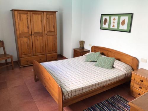 法马拉Casa Beatriz的一间卧室配有一张带两个枕头的木床