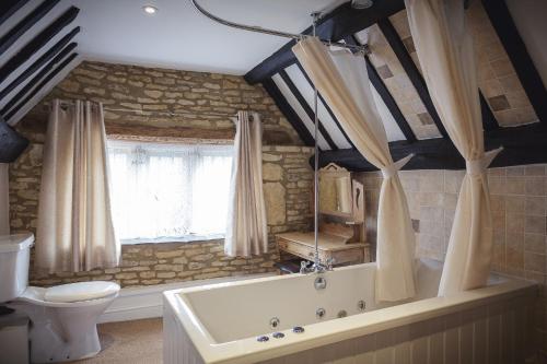 水上伯顿小羊旅馆的带浴缸和卫生间的浴室。
