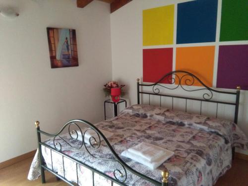 文佐内Casali Scjs的一间卧室配有一张带彩色墙壁的床