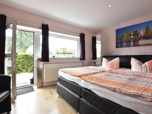 海利根达姆Cozy Apartment near Forest in Heiligendamm的一间卧室设有一张床和一个大窗户