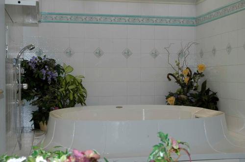 莫埃纳黛布拉公园酒店的浴室设有白色浴缸,并装饰有鲜花。