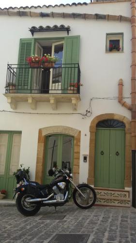 桑布卡迪西奇利亚Le Stanze dell'Emiro的停在有绿门的建筑物前的摩托车