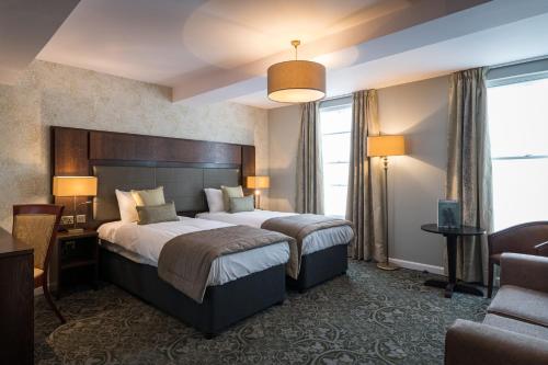 蒙默思The King's Head Hotel - JD Wetherspoon的酒店客房带一张大床和一把椅子