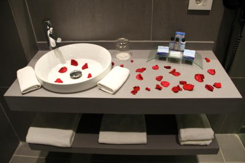 杰赫Pangea Beach Resort的浴室水槽上装有红色玫瑰花瓣
