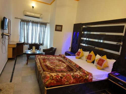 阿格拉Hotel Taj Plaza, VIP Road, Agra的酒店客房设有一张大床和一张桌子。