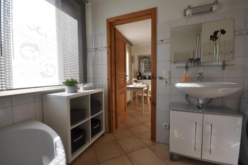 吕贝克Ferienhaus Abendsonne的一间带水槽、卫生间和镜子的浴室