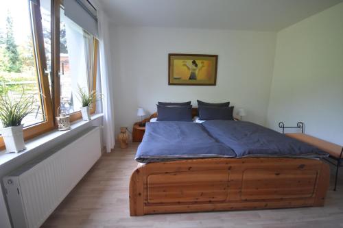吕贝克Ferienhaus Abendsonne的一间带木床的卧室,位于带窗户的房间内