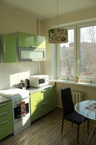纳尔瓦Happy Day的厨房配有绿色橱柜和桌子