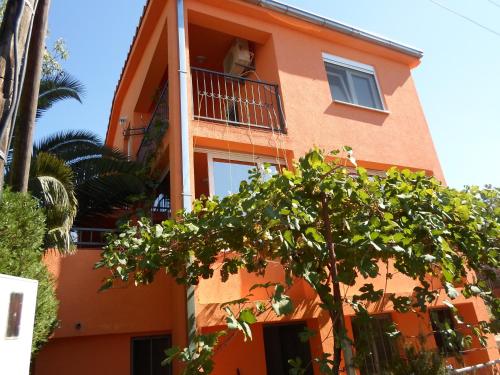 尤塔哈Holiday home Orange family apartments的一座橘色的建筑,前面有一棵树