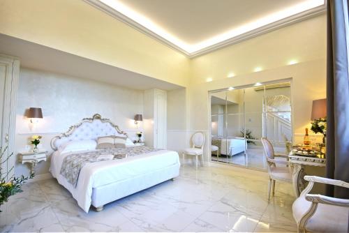 佛罗伦萨The Moon Boutique Hotel & Spa的一间带白色床和书桌的卧室以及一间客房