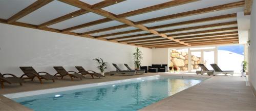巴迪亚Agriturismo Anví的客厅设有游泳池、椅子和游泳池