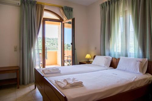 圣特里亚斯Villa Tinadora的一间卧室设有一张床和一个阳台的窗户。