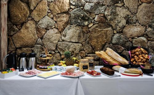 皮亚诺托利-卡尔达雷洛Macchie e Fiori的一张桌子,上面有食物,旁边是石墙