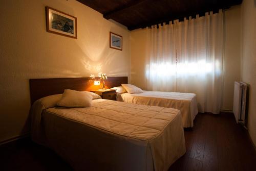 MoralinaLos Arribes的酒店客房设有两张床和窗户。