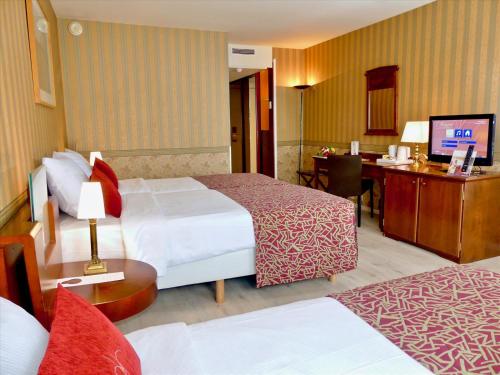 德美第奇金色郁金香酒店客房内的一张或多张床位