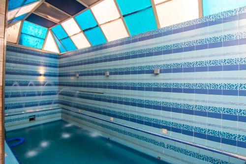 拉比格Rabigh Tower Hotel的游泳池拥有蓝色和白色的瓷砖墙壁和窗户