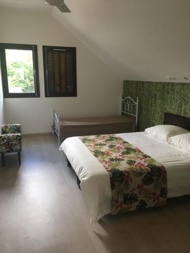 勒唐蓬Caloupilé的一间卧室设有一张大床和一个窗户。