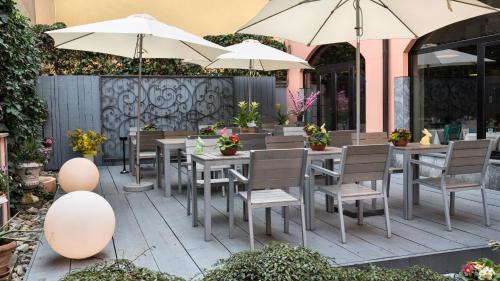 米兰伦巴蒂雅酒店的一个带桌椅和遮阳伞的庭院
