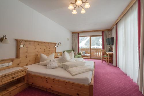 乌姆豪森陶菲伯格酒店的一间卧室配有一张大床和木制床头板