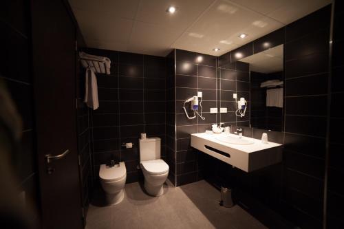 雷乌斯布瑞亚之家酒店的一间带卫生间、水槽和镜子的浴室