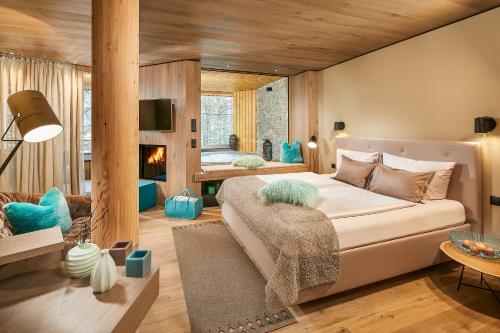 朗根费尔德Naturhotel Waldklause的一间卧室设有一张大床和一个壁炉