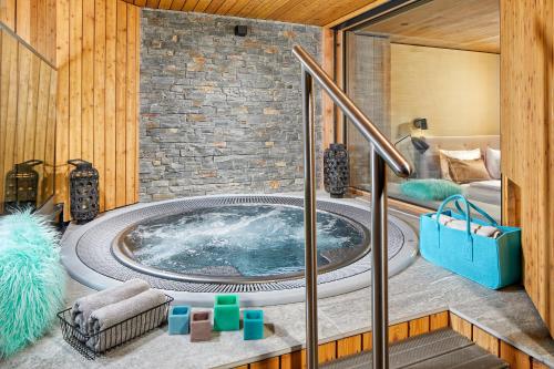朗根费尔德Naturhotel Waldklause的一个带按摩浴缸的床铺客房