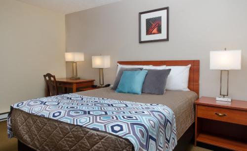 蒙克顿蒙克顿/迪耶普海岸酒店的一间卧室配有一张带2个床头柜和2盏灯的床。