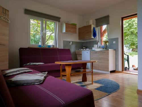 ZełwągiDomki letniskowe "Pod lipą"的客厅配有紫色沙发和桌子