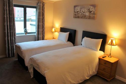 莱特肯尼Wild Atlantic Accommodation 18 Glenveagh Court的酒店客房设有两张床和窗户。