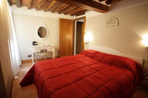 蒙特普齐亚诺Mezzanino L Palazzo Gagnoni Grugni的一间在房间内配有红色床的卧室