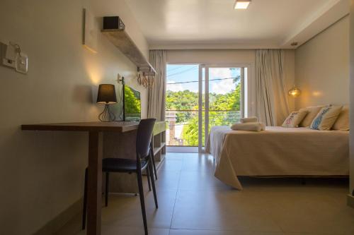 莫罗圣保罗Pousada Renda do Mar的客房设有两张床、一张桌子和一个窗户。