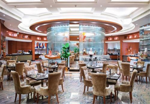 东莞东莞石碣富盈酒店的一间带桌椅的餐厅和一间酒吧