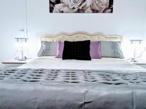 马尔泰拉戈瓦内萨住宿加早餐旅馆的白色的床,上面有紫色和黑色枕头
