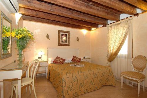 威尼斯Ca' Dei Leoni的卧室配有一张床和一张桌子及椅子