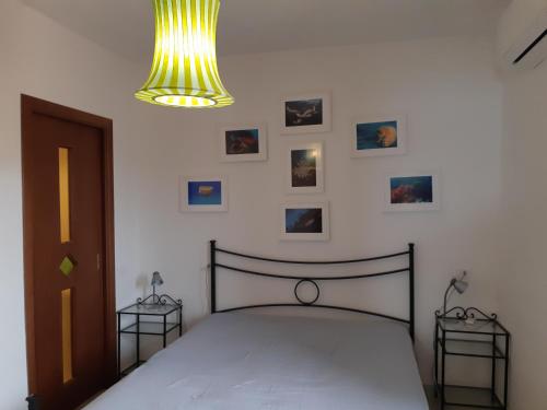 康培斯Campese Apartments的一间卧室配有一张床、吊灯和图片