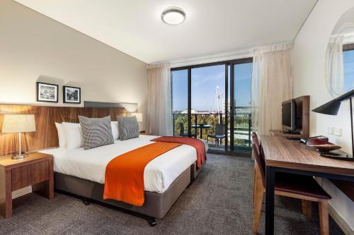 悉尼悉尼奥林匹克公园凯斯特公寓式酒店的一间卧室配有一张床和一张带电脑的书桌