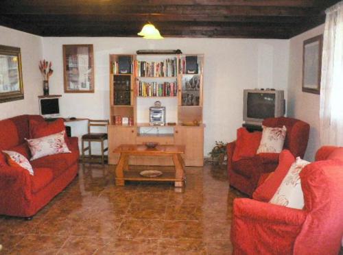 塔伊切Casa Albryna Lanzarote Rural Villa, Pool Wifi的客厅配有2把红色椅子和桌子