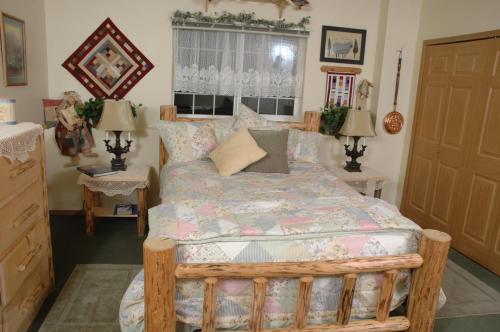 瓦西拉阿拉斯加湖露西尔食宿酒店的一间卧室配有一张床、两张桌子和两盏灯。