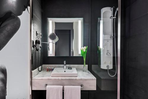 马德里特拉纳北西方酒店的一间带水槽和镜子的浴室