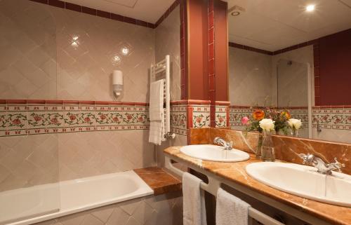 马德里奧地利唐胡安阿果拉酒店的浴室配有两个盥洗盆和浴缸。